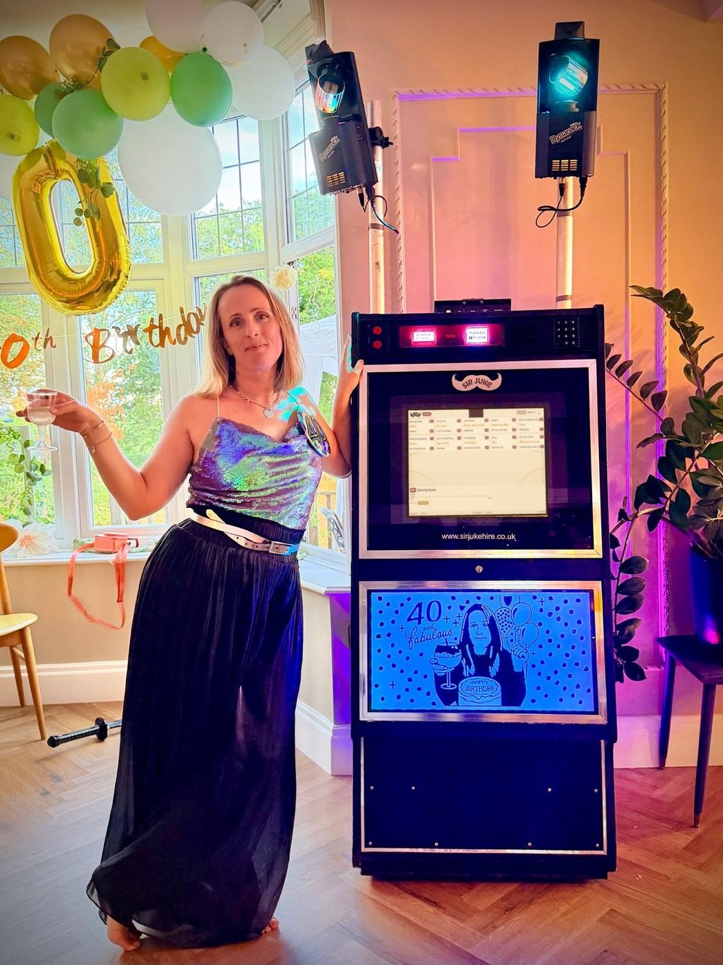Birthday guest beside the Sir Juke jukebox, with a personalised 40 and Fabulous light box and two FX lights